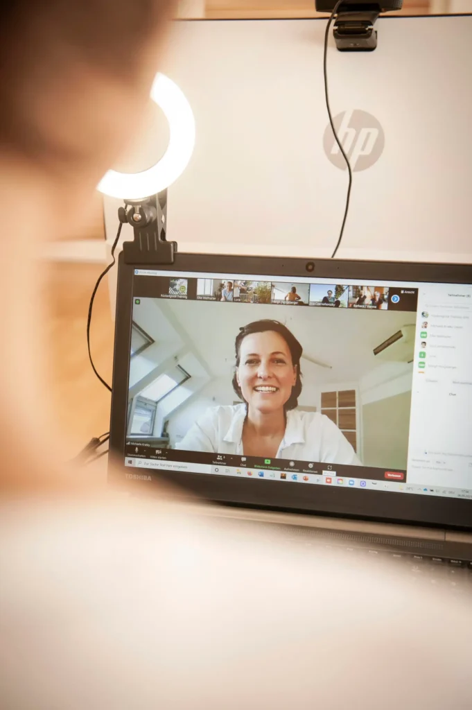 Trainerin Michaela Kratky leitet ein Online-Rückentraining per Zoom auf einem Laptopbildschirm