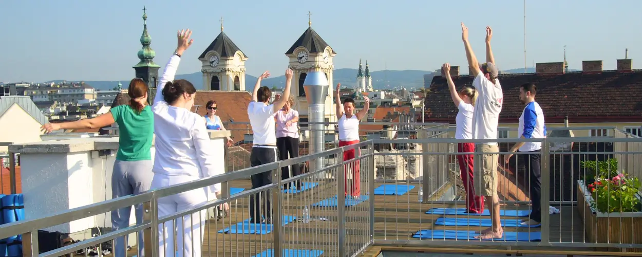 Rückenglück Gruppentraining auf Dachterrasse mit Blick über Wien